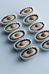 Composition of delicious praline sweets with almonds on blue background
