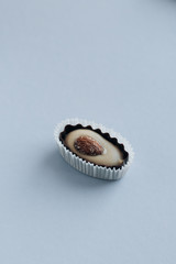 Composition of delicious praline sweets with almonds on blue background