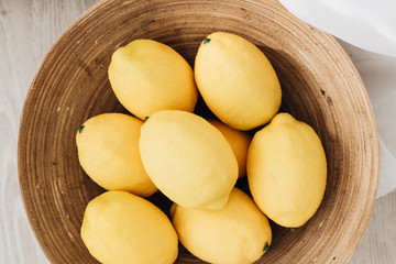 Naklejka na ściany i meble Pile of fresh lemons in wooden bowl