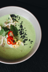 Delicious green spicy soup in white bowl