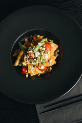 Fresh healthy dinner with seeds and vegetables on black plate