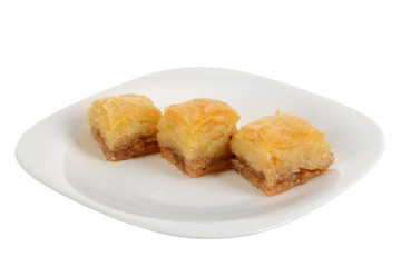 Traditional oriental dessert baklava with syrup.Three pieces of baklava on plate, isolated