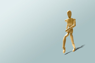 Wooden mannequin in a running pose. Wooden model on the run. Morning running, training. Jogging. The figure of wood runs on a pastel blue background. Caring for a physical condition concept.