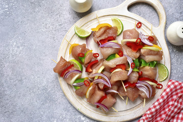 Chicken skewers (kebab) from meat fillet and vegetables (bell pepper,red onion and lime) prepared for marinating.Top view with copy space.