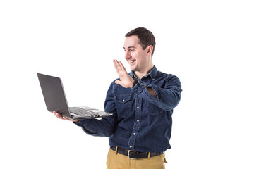 young programmer (man) holding a laptop in hands and talking on skype with friends isolated on...