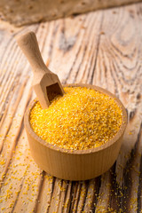 Corn groats in bowl on a wooden background. Healthy dietary cereals concept.