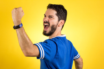 Brazilian supporter of National football team is celebrating, cheering. Male fan.