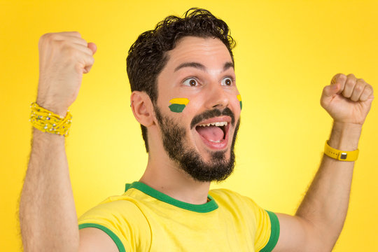 Brazilian supporter of National football team is celebrating, cheering. Male fan.