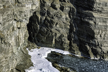 Fototapeta premium Small cave in a rock winter view with snow and ice floes in the sea