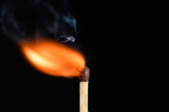 Match with flame blows off to the side on a black background closeup