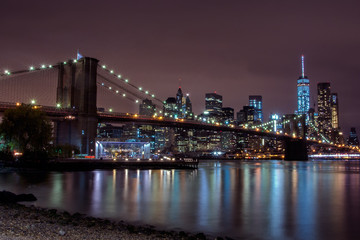 Fototapeta na wymiar Purple sunset view of Brooklyn bridge and lower Manhattan skyline