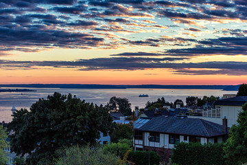 Colorful sunset over the houses in Seattle with a sea view