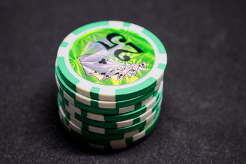 A stack of green chips with denomination of twenty-five on a dark background. Passion, play, poker, casino.