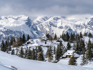 Fototapeta premium Traditional cottages on Velika planina in winter, Slovenia