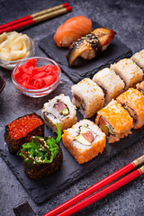 Sushi and roll set on black table