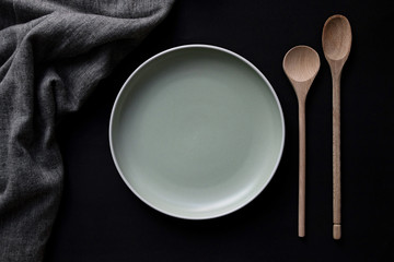 empty plate with spoon flat lay on black background 