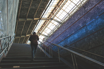 the man climbs the stairs at the station, retro toned