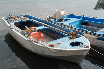 Blaues, altes Ruderboot mit Stuhl