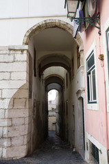 Fototapeta na wymiar Narrow and tall archway in Alfama district, Lisbon