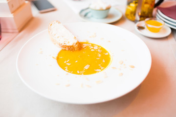 Onion cream soup with toast. Vegetable cream soup with pumpkin in a white bowl and a slice of bread with cheese. Healthy food. Healthy diet meal.