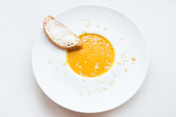 Onion cream soup with toast. Vegetable cream soup with pumpkin in a white bowl and a slice of bread with cheese. Healthy food. Healthy diet meal.