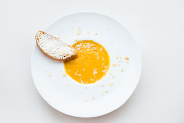 Onion cream soup with toast. Vegetable cream soup with pumpkin in a white bowl and a slice of bread with cheese. Healthy food. Healthy diet meal.