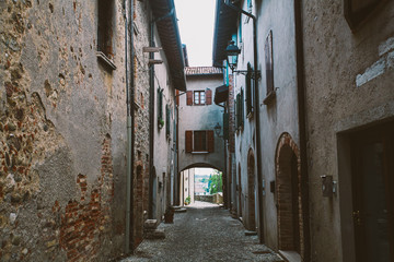 Fototapeta na wymiar old narrow alley in tuscan village - antique italian lane in Montalcino, Tuscany, Italy.