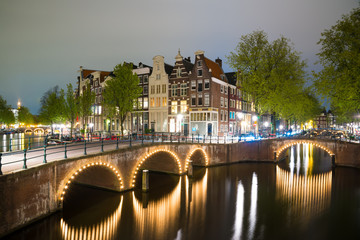 Obraz premium Amsterdam canal, bridge and typical houses during evening twilight blue hour