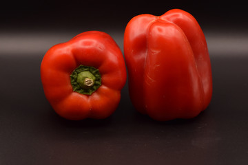 Tasty bright red peppers on a seamless black background. 