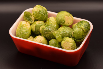 Seasoned Brussel sprouts on a black background. 