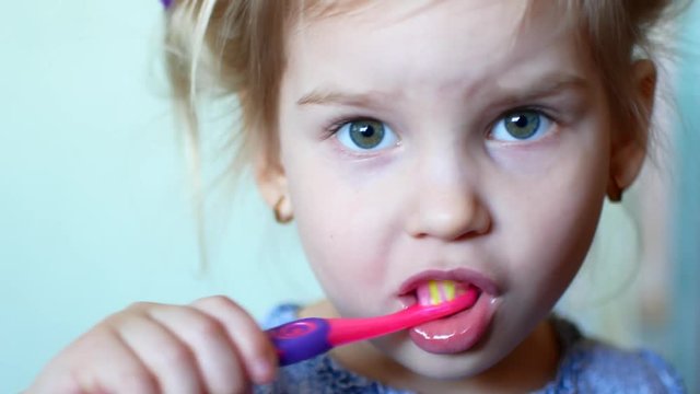 Little girl diligently brushing his teeth