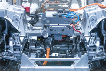 Chassis of the electric car with powertrain and power connections closeup. Blue toned.