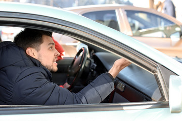 Fototapeta na wymiar Emotional man inside car in traffic jam