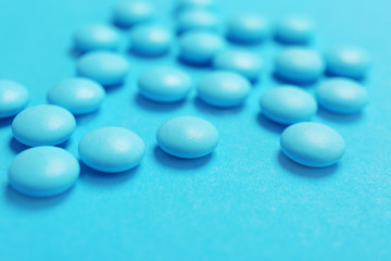 Blue pills on color background