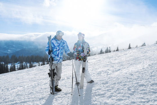 Couple on ski piste at snowy resort. Winter vacation