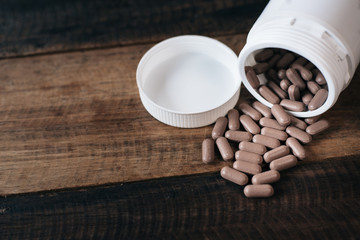 pills and  bottle on wooden table.healthcare and medical concept