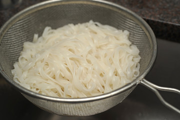 Boiled rice noodles in sieve