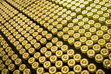 Hundreds of brass ammo rounds lined together - obrazy, fototapety, plakaty