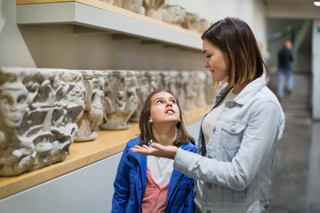 Mother and daughter regarding classical bas-reliefs