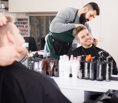 Glad guy creating shape for beard of client