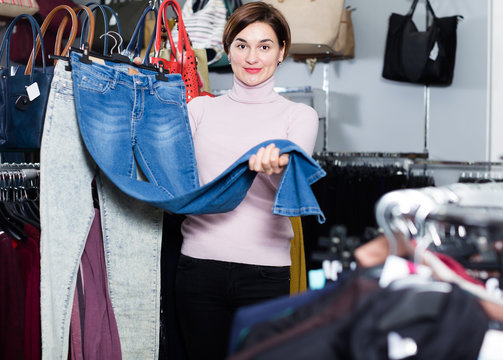 Positive girl deciding on new jeans