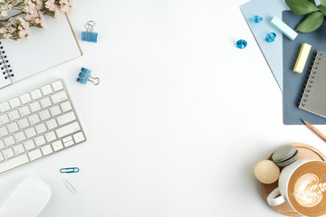 Styled stock photography navy blue office desk table with blank notebook, keyboard, macaroon, supplies and coffee cup. Top view with copy space. Flat lay.