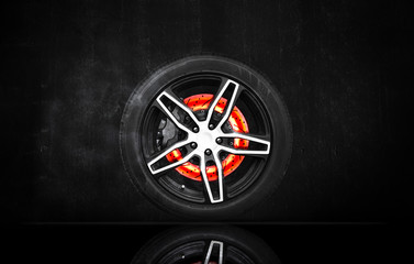 3D rendering, Disc brake scratch burning in a racing wheel on black cement wall background. Automotive parts concept.