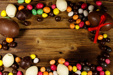 Easter composition with chocolate eggs on wooden background