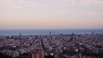 A time lapse of Barcelona, Spain. It is sunset time and the sun is almost gone. The Mediterranean sea is at the back. The view is taken from the antiaircraft refugee.