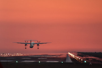 Fototapeta na wymiar 夕焼けに飛び立つプロペラ飛行機　A propeller plane flying at sunset