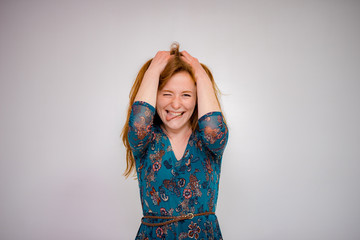 Cute beautiful red-haired girl shows different emotions in different poses on different background in different clothes