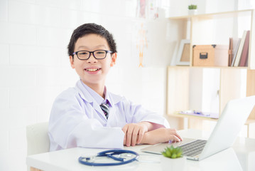 Obraz na płótnie Canvas Young asian boy pretend to be a doctor in hospital