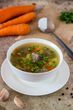 Soup with meat, potatoes and carrot. Beef soup in a white bowl