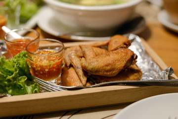 Fried chicken wings on plate with dipping sauce.